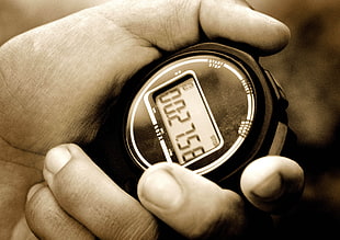 grayscale photography of person holding stopwatch at 27.58 seconds