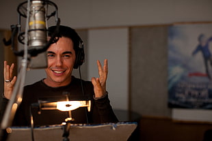 man in front of a silver studio microphone