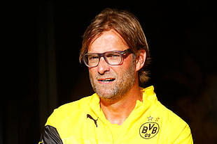 man in yellow tops and clear eyeglasses posing for photo