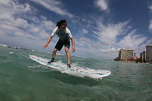 man playing longboard surfboard on beach