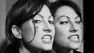 grayscale photography of woman with black star tattoo on face