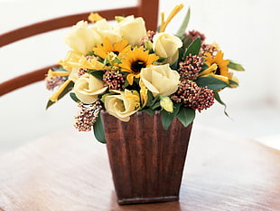 yellow flowers in brown vase