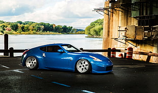 photo of blue coupe beside lake
