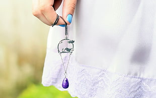 shallow focus photography of person holding dangling earrings