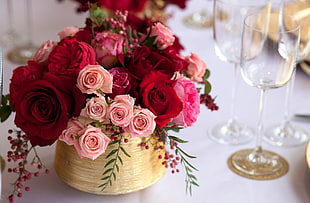 pink and red Rose flower arrangement beside wine glasses