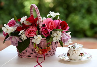shallow focus photography of flowers in pink basket on table