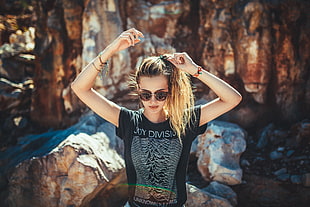 woman wearing black t-shirt and sunglasses beside rock formations HD wallpaper