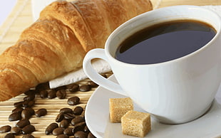 cup of coffee with sugar cubes and bread
