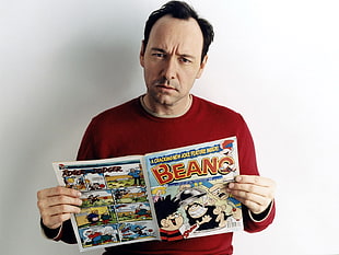 man in red sweater reading Beano book HD wallpaper