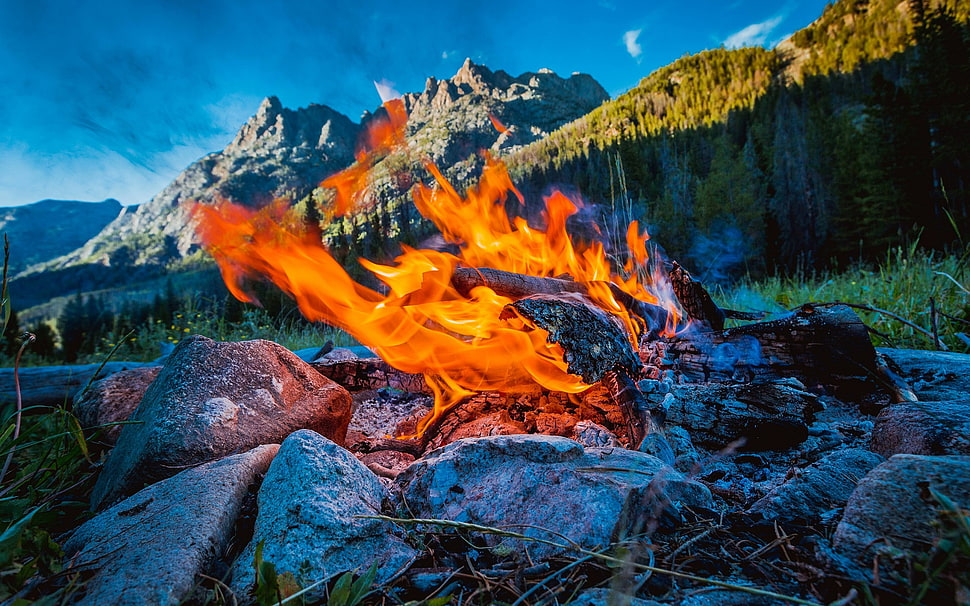 flames near mountain at daytime HD wallpaper