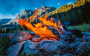 flames near mountain at daytime