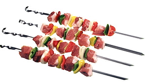 four raw meats and veggies on skewers