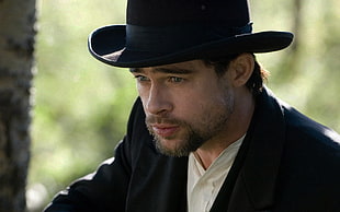 shallow photography of brad pitt in black suit jacket and black bowler hatt