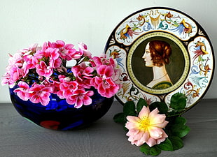 photo of pink petaled flowers in blue glass vase