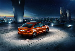orange sedan on top of building with spotlight photograph