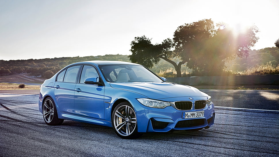 blue BMW sedan on concrete road HD wallpaper