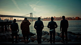 five person standing on bench near bridge