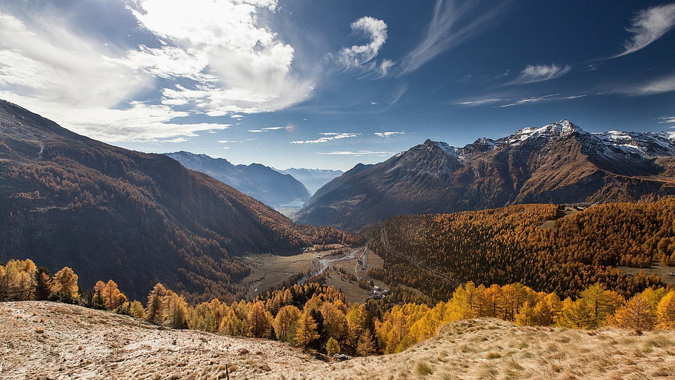 mountains surrounding valley under cloudy sky HD wallpaper