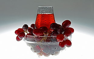 red grapes with juice labeled glass