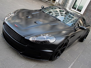 black Aston Martin DB9 parked on concrete pavement