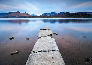 gray stone dock on body of water