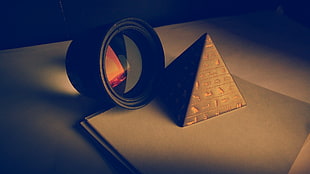 shallow focus photography of gray pyramid miniature beside lens