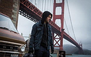 man in blue jacket underneath Golden State  bridge