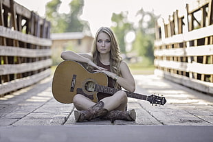 woman siting on the bridge  with guitar on her lap