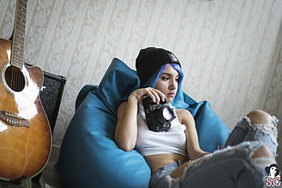 woman sitting on blue couch inside room