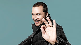 man wearing jacket smiling and raising left hand HD wallpaper