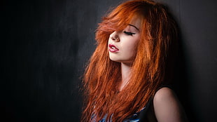red-haired woman leaning on wall