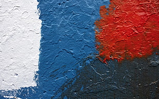 closeup photo of red, blue, white, and black wall paint