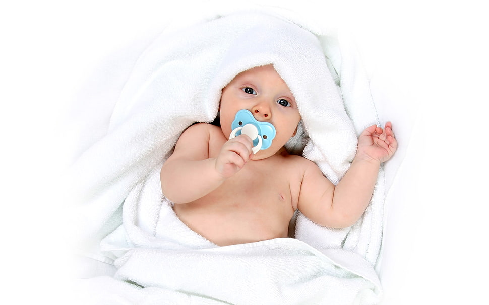 baby with blue pacifier lying on white blanket HD wallpaper