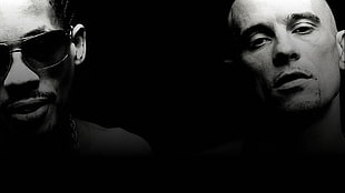 grayscale photo of two men against black background