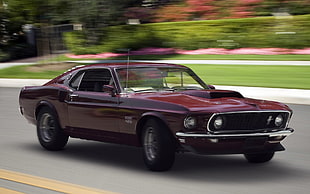 maroon Ford Mustang on gray top road