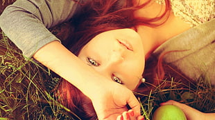 red haired woman lying on grass