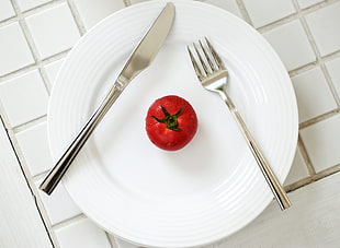 red tomato on white ceramic plate