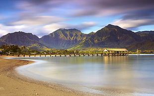 panoramic photography of dock in beach with a background of mountains during daytime HD wallpaper
