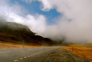 asphalt road near clouds
