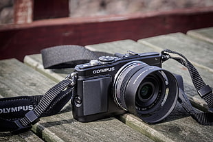 black Olympus SLR camera on wood planks HD wallpaper