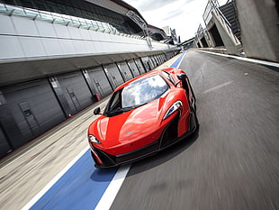 red and black Mclaren sports car on race track