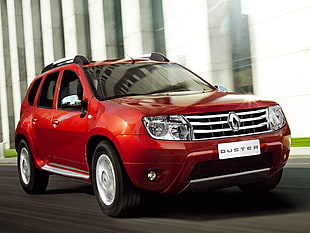 red Renault Duster running on road near building