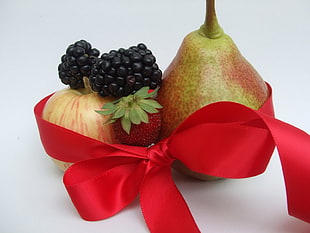 still-life photo of variety of fruits with ribbons
