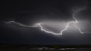 landscape photography of sea under thunder during nighttime