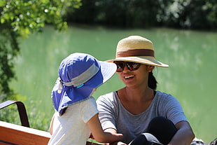 woman and child near calm body of water during daytime HD wallpaper