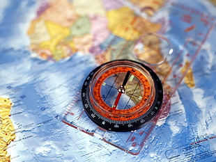 compass on plastic ruler and world map