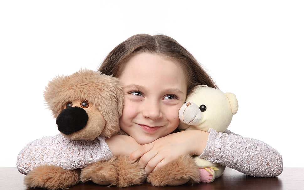 girl leaning on brown wooden panel while hugging two yellow bear and brown dog plush toys HD wallpaper