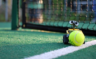 Macro shot photography of wall-e holding tennis ball
