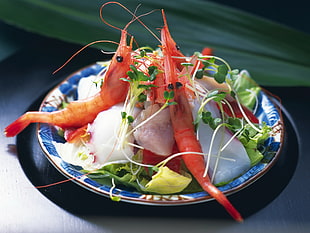 three shrimps with green veggies on plate