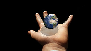 force perspective human hand holding globe \